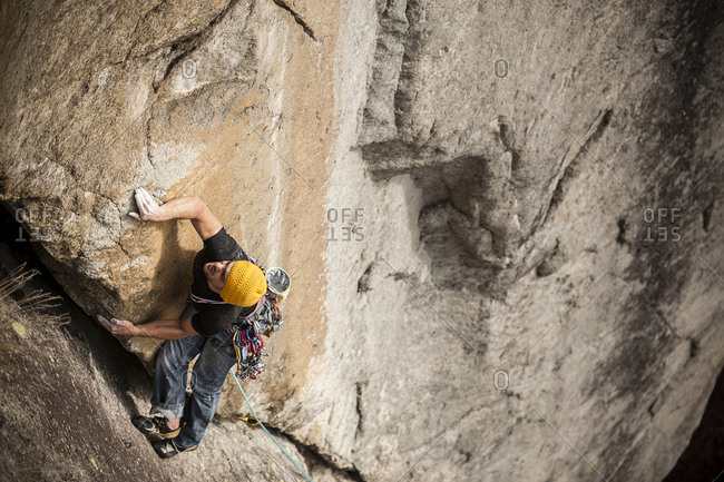 Man lead climbing a two pitches crack route in traditional style, Cadarese, Ossola Valley, Italy