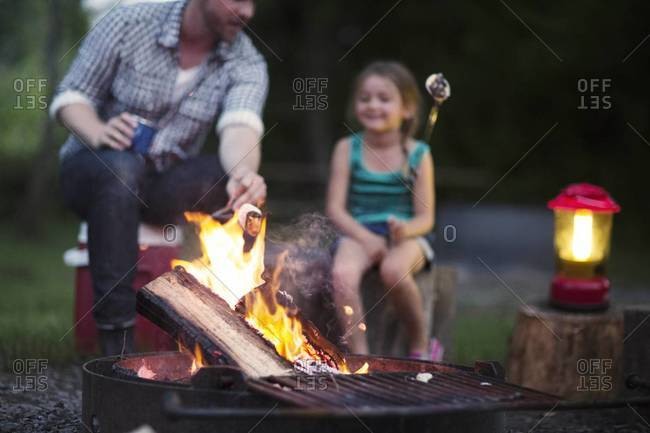 Father and daughter roasting marshmallows