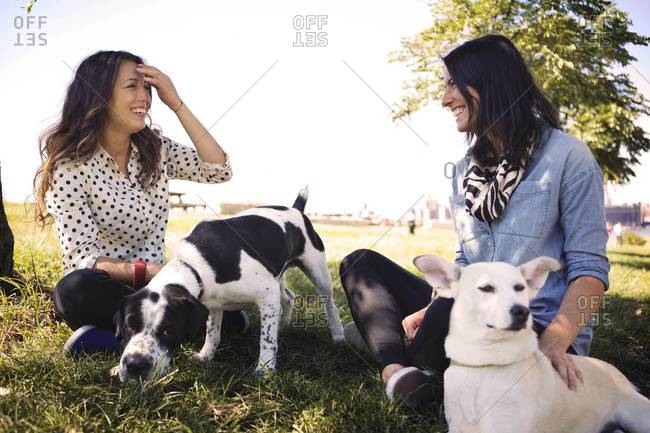 Two young woman and their dogs in the park