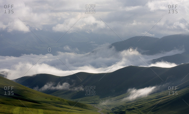 Clouds sweep through rolling green hills