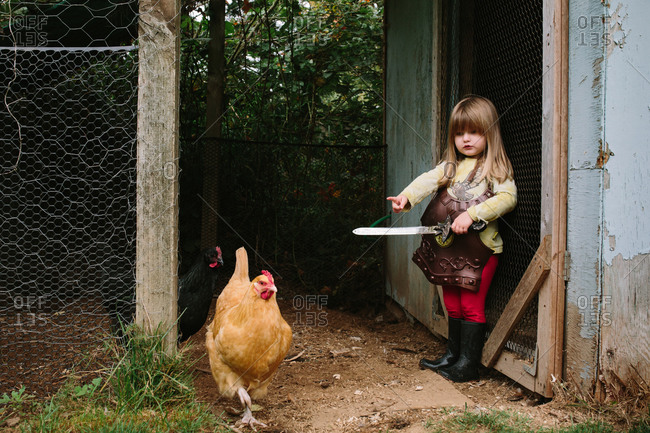 Girl in knight costume by chicken coop