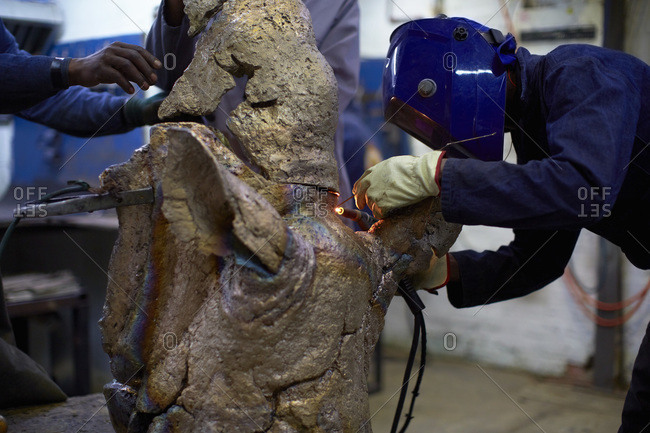 Art foundry worker welding cast parts, Cape Town