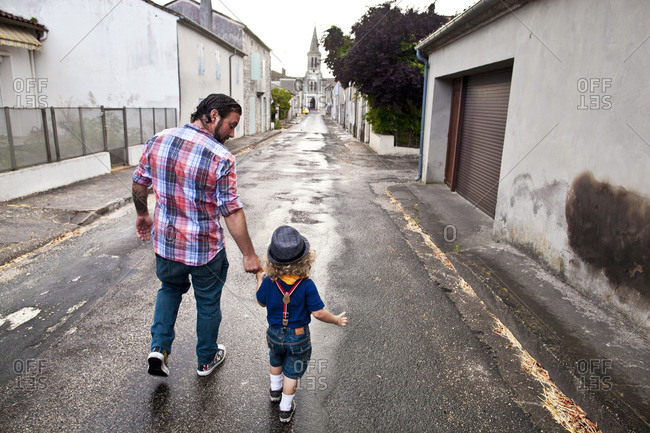 Father walking with his son on a street in France