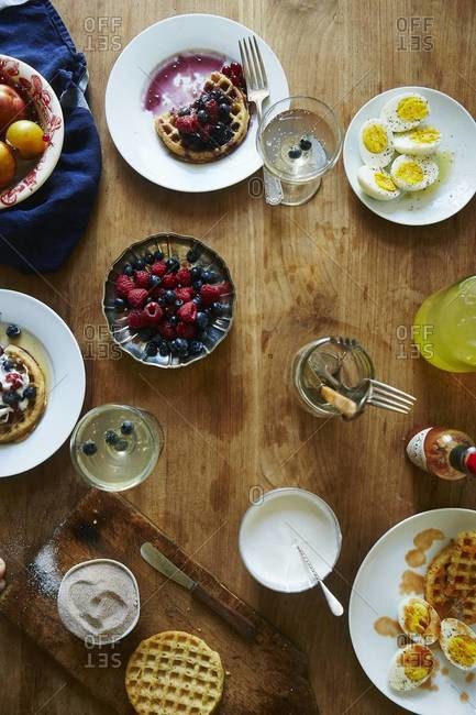 Waffels with ripe fruits and halved eggs served on a table