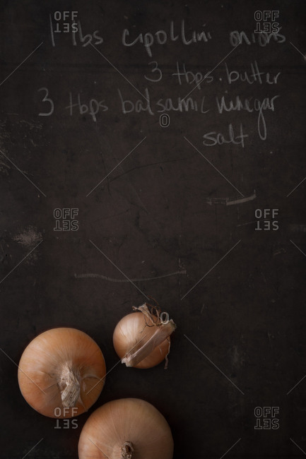 Raw onions on a chalk board with a recipe