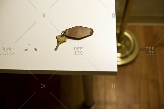 Motel room key on white table