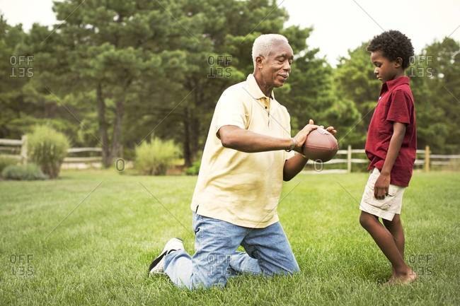 Older man showing boy how to throw football