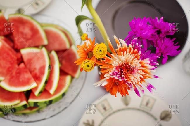 Watermelon and flowers on picnic table