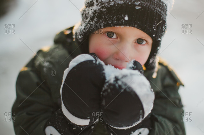 Portrait of a young boy eating snow