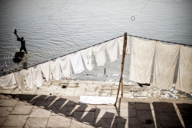 Man washing clothes in the Ganges river in Varanasi, India