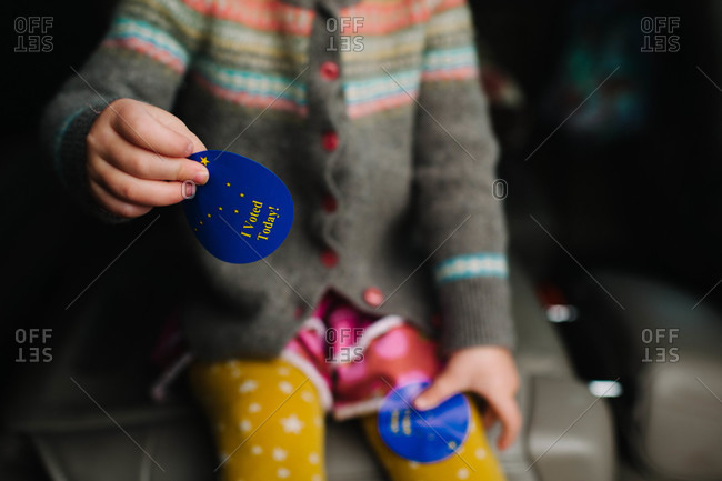 Young girl holding voting stickers
