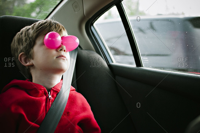 Boy in car covering eyes with Easter egg