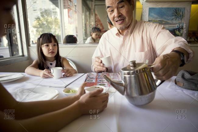 Man serving tea in restaurant for girls