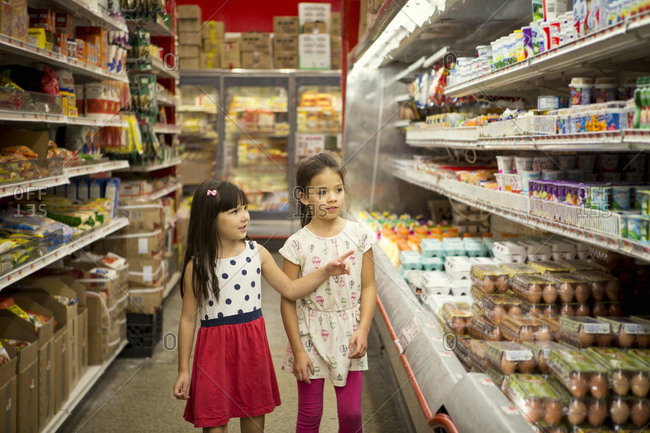 Two girls in dairy aisle in store