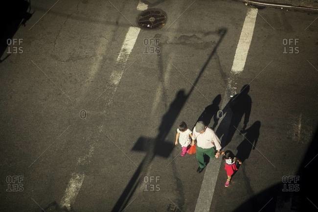Man and two girls crossing street from above