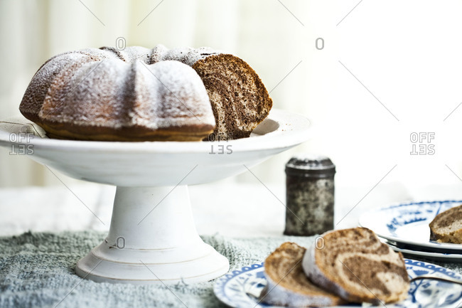 A vanilla and cocoa bundt cake on a cake stand