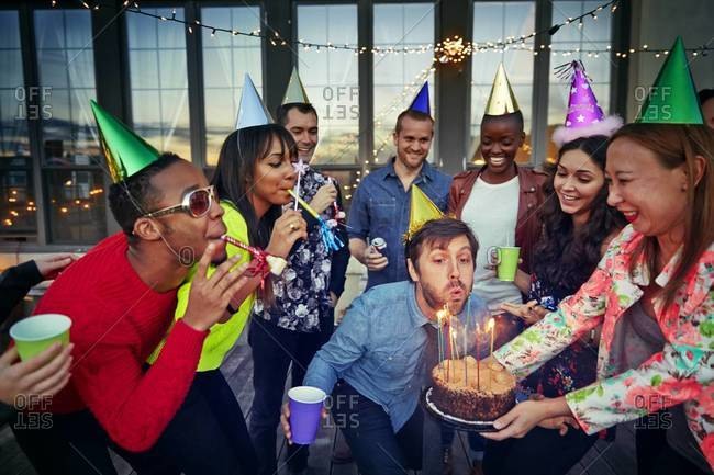 Multi-ethnic group celebrates a friend's birthday