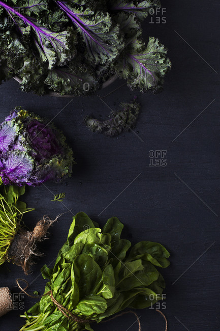 Overhead view of green leafy vegetables on black background