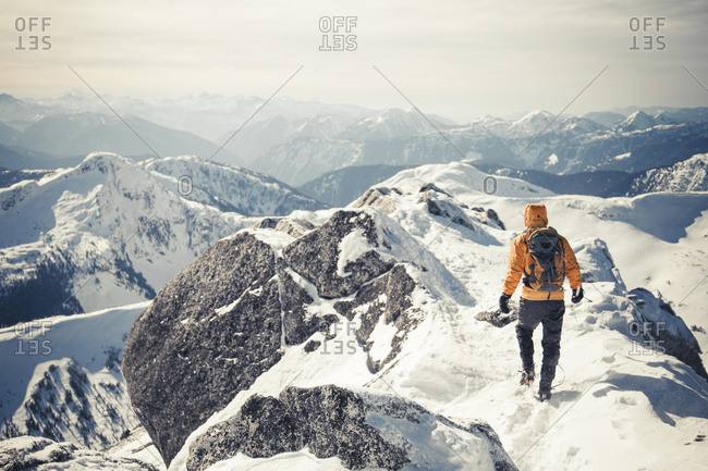 A climber walks a mountain ridge during winter in the Coquihalla Recreation Area of British Columbia, Canada