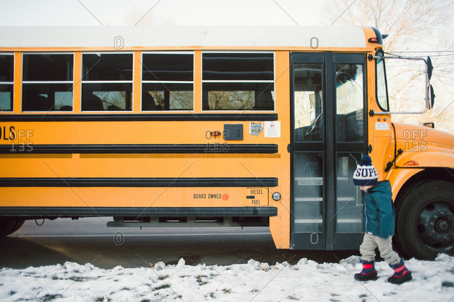 A boy walks past a school bus