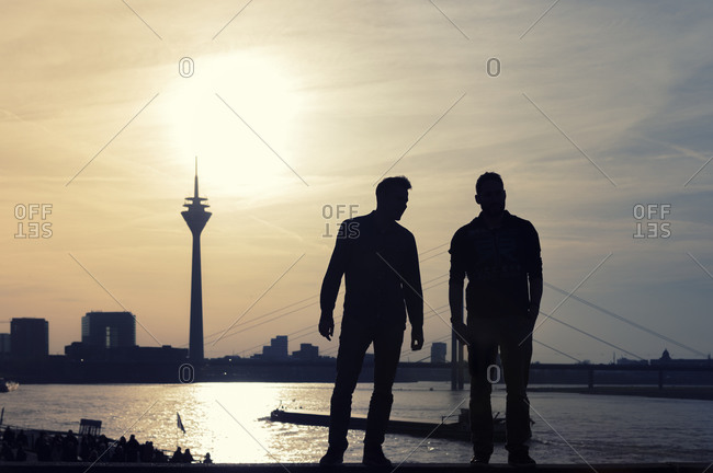 Two man looking to Rhine tower and Rhine river at sunset, Dusseldorf