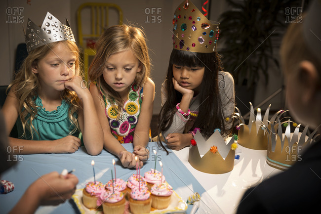 Children at birthday party watch candles being lighted