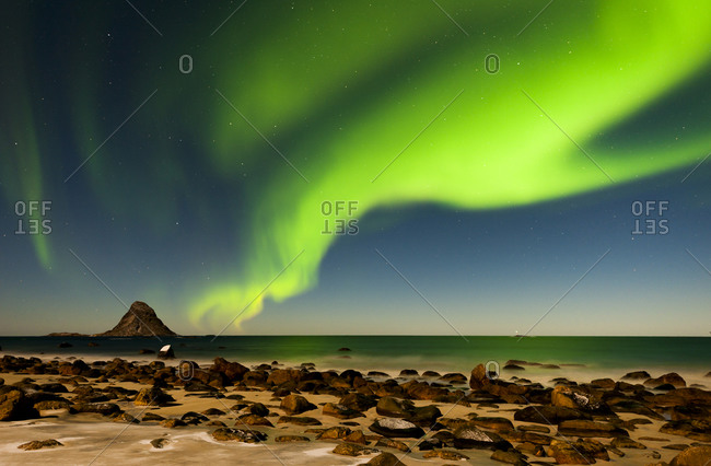 Aurora Borealis glimmering over beach