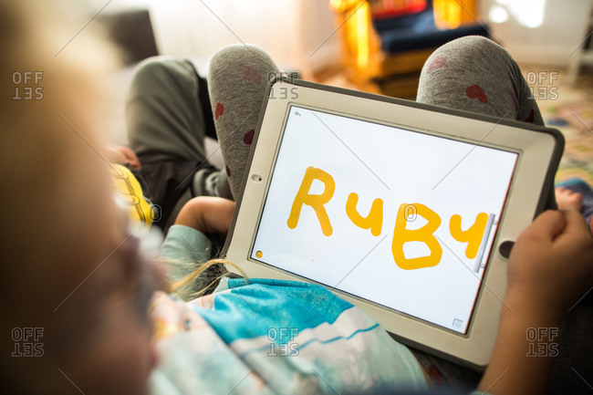 Siblings drawing letters on tablet