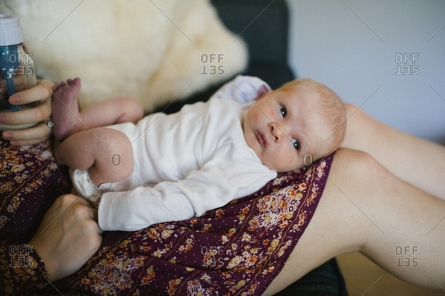 Close-up of alert infant resting on mother\'s lap