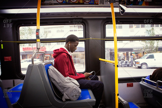 Teenage boy looking at his smartphone on a bus