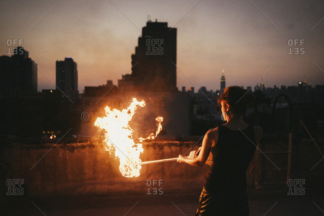 Woman holding a flaming torch at dusk