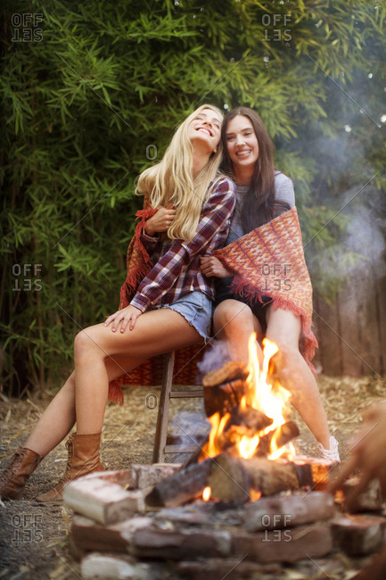 Two women sitting together by fire