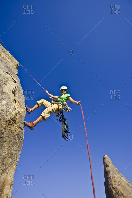 Low angle view of woman descending from a cliff