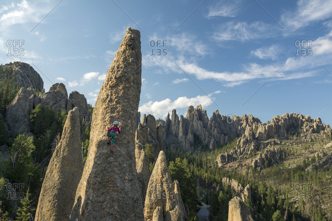 A young girl rock climbing in the Black Hills, Custer State Park, Hill City, South Dakota.