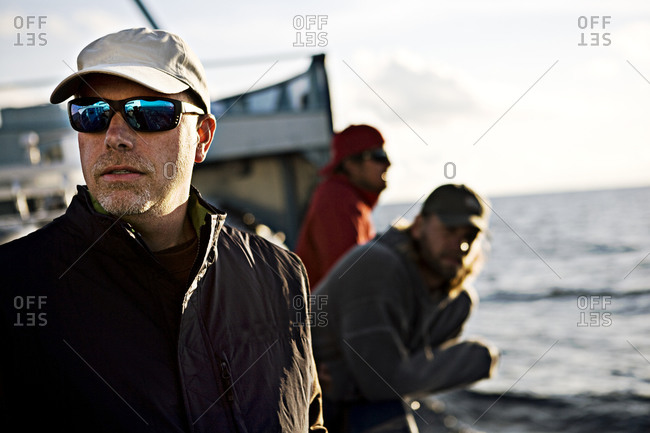 Scientist looks out while standing aboard research boat