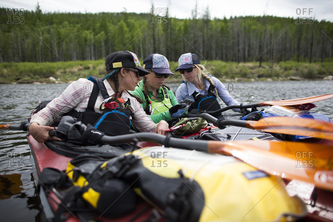 Three women check the GPS for logistical reasons before they continue paddling down the Onon river in northern Mongolia.