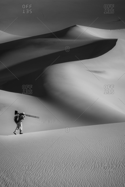 A man hiking with camera in Great Sand Dunes National Park in Colorado, USA