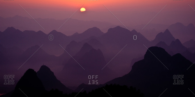 Mountains in early morning fog with the sun rising in  Gulilin, Guangxi, China