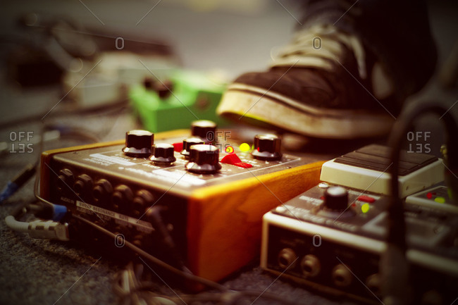 A musician steps on a guitar pedal