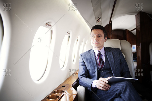 Businessman holding a tablet on a private jet