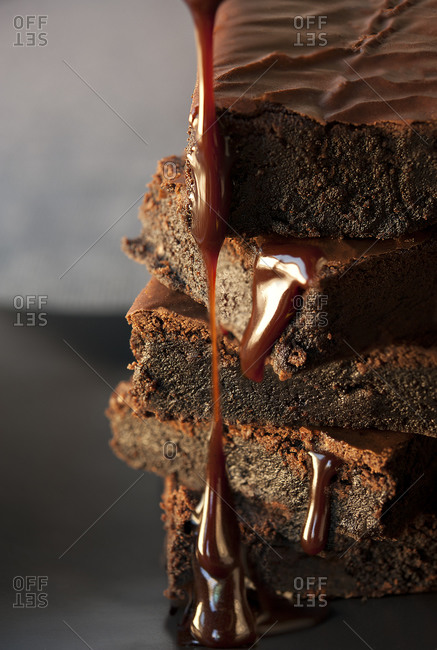 A stack of chocolate brownies with dripping chocolate fudge