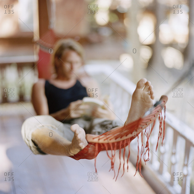 Young man in a hammock reading a book