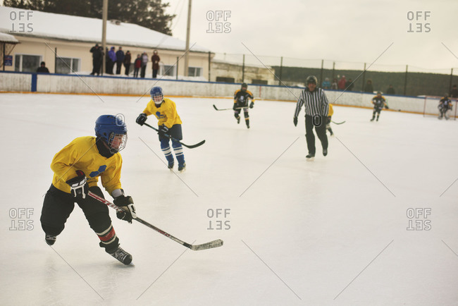 Boys playing ice hockey and referee
