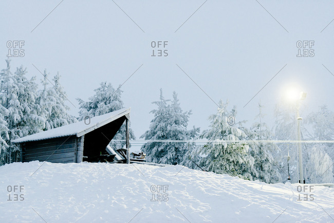A fire burring in a lean-to in the snowy Swedish landscape