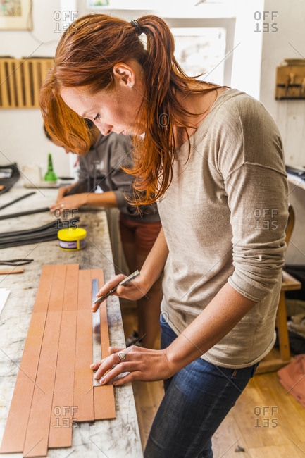 Woman cutting elastic fabric rubber band in saddlery