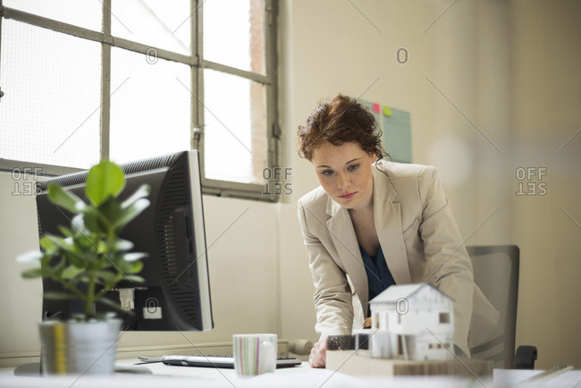 Young woman in office looking at architectural model