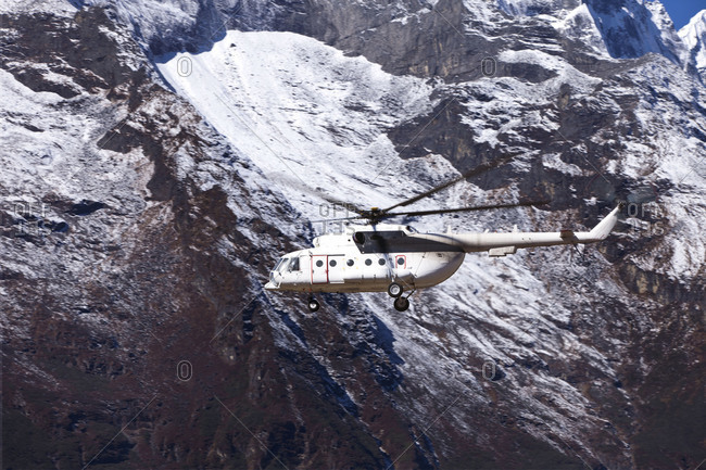A helicopter flying in the Himalayan mountains