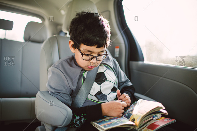 Boy reading comic books in car