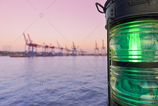 View to harbor at twilight with navigation light in the foreground, Hamburg