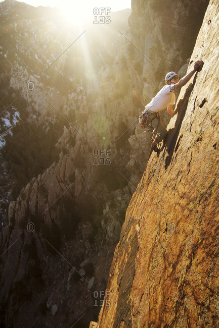A rock climber scaling a flat rock face